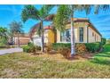 Exterior shot of home featuring well-manicured landscaping, terracotta roof, and tan stucco exterior at 24181 Gallberry Dr, Venice, FL 34293