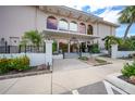 A charming building entrance with beautiful landscaping, architectural details, and a welcoming pathway at 25188 Marion Ave # D308, Punta Gorda, FL 33950