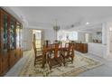 A formal dining room features a wooden table with seating for six, chandelier, and a mirrored wall at 25188 Marion Ave # D308, Punta Gorda, FL 33950