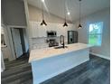 Modern kitchen with quartz countertops, stainless appliances, a herringbone backsplash, and stylish pendant lighting at 302 Albatross Rd, Rotonda West, FL 33947