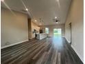 Bright living space with vaulted ceilings flowing into the modern kitchen and large windows at 302 Albatross Rd, Rotonda West, FL 33947