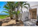 Exterior view of property entrance featuring tropical landscaping, gravel and charming decorative heron statues at 4692 Club Dr # 101, Port Charlotte, FL 33953
