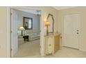 Inviting foyer with tile flooring, complemented by a decorative cabinet and a glimpse into the elegant living room at 4692 Club Dr # 101, Port Charlotte, FL 33953