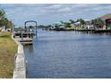 Picturesque waterfront view showcasing docks, boats, and waterfront homes under a partly cloudy sky at 5234 Forbes Ter, Port Charlotte, FL 33981