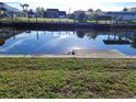 Waterfront with a seawall and calm water reflecting nearby houses and the clear blue sky above at 5234 Forbes Ter, Port Charlotte, FL 33981