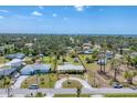Wide aerial shot of a quiet neighborhood showcasing lush tree canopy with the home in the center at 551 Morrison Ave, Englewood, FL 34223