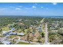 Expansive aerial view of the neighborhood showcasing mature trees and a glimpse of the coastal waterway at 551 Morrison Ave, Englewood, FL 34223