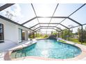 Enjoy the crystal-clear waters of this screened in-ground pool with waterfall feature and lush greenery at 60 N Oxford Dr, Englewood, FL 34223