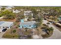 Overhead shot of a light blue single-story home with mature trees, offering privacy and a serene setting at 7035 Duke St, Englewood, FL 34224