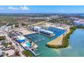 Aerial view of a marina with boat docks, waterfront condos, and a pool overlooking tranquil waters at 7070 Placida Rd # 1230, Placida, FL 33946