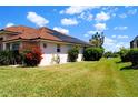 Exterior shot showcasing landscaping, including a view of water, and the property's beautiful tile roof at 76 Sportsman Rd, Rotonda West, FL 33947