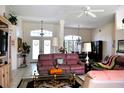 Spacious living room features tile floors, a ceiling fan, and a lovely view into the dining area at 76 Sportsman Rd, Rotonda West, FL 33947