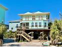 Charming coastal home on stilts with a spacious porch and beautiful exterior paint at 8152 Little Gasparilla Is, Placida, FL 33946
