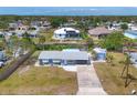 Aerial view of a blue home with a long driveway, storage shed, and canal access at 832 E 4Th St, Englewood, FL 34223