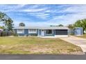 Quaint single-story home with a well-kept lawn, a long driveway, and a detached storage shed at 832 E 4Th St, Englewood, FL 34223