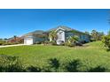 Well-maintained single-story home featuring an attached garage, beautiful lawn, and mature trees at 1078 Boundary Blvd, Rotonda West, FL 33947