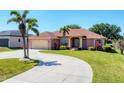 Charming home featuring a well-manicured lawn, decorative palms and a circular driveway at 1080 Boundary Blvd, Rotonda West, FL 33947