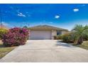 Charming single-story home boasting a two-car garage, long driveway, and mature landscaping at 116 Albatross Rd, Rotonda West, FL 33947