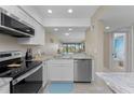 Modern kitchen with stainless steel appliances, granite countertops, and views of the living area at 1551 Beach Rd # 412, Englewood, FL 34223