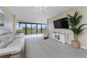 Bright living room with a ceiling fan and sliding glass doors leading to a balcony with views at 1551 Beach Rd # 412, Englewood, FL 34223