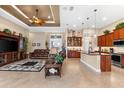 Open-concept living area with ceiling fan, tile floors, modern lighting, and seamless transition to the kitchen at 15588 Ruston Cir, Port Charlotte, FL 33981
