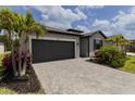 Charming single-story home featuring a two-car garage, and landscaped front yard at 15968 Honeysuckle St, Port Charlotte, FL 33953