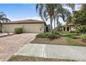 Well maintained property featuring a brick paved driveway and colorful landscaping at 20171 Tesoro Dr, Venice, FL 34293