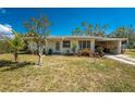 Charming single-story home featuring a carport, a well-maintained lawn, and mature landscaping at 2033 Georgia Ave, Englewood, FL 34224