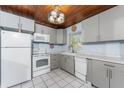 Well-lit kitchen with white appliances, gray cabinets, and a window at 2033 Georgia Ave, Englewood, FL 34224