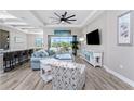 Bright living room boasts stylish furniture, wood-look flooring, and sliding glass doors to the lanai at 212 Rotonda E Blvd, Rotonda West, FL 33947