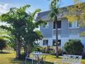 Relaxing outdoor seating area with lush trees and greenery surrounding the condo building at 22375 Edgewater Dr # F219, Port Charlotte, FL 33980