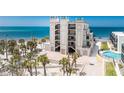 Stunning exterior view of the condo building with direct beach access, palm trees, and lush landscaping at 2792 N Beach Rd # 301, Englewood, FL 34223