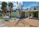 Exterior of home with gravel driveway, lawn, palm trees, angular roof, and carport at 2980 N Beach Rd # Gv16, Englewood, FL 34223