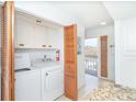 Efficient laundry room features a washer, dryer, storage cabinets, and easy outdoor access at 301 S Gulf Blvd # 419, Placida, FL 33946