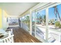Inviting screened porch with beach views, wooden flooring and white railing at 342 S Gulf Blvd, Placida, FL 33946