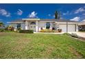 Charming single-story home featuring a well-manicured lawn, arched windows, and double-door entrance at 4 Bunker Rd, Rotonda West, FL 33947