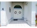 Elegant double front door with decorative wreaths and white tiled entryway at 4 Bunker Rd, Rotonda West, FL 33947