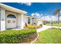 Charming home features manicured hedges, lush landscaping, and elegant double doors at 4 Bunker Rd, Rotonda West, FL 33947