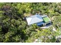 Aerial view of home with metal roof, set amongst lush tropical foliage and manicured lawns at 425 Laurel W Rd, Nokomis, FL 34275