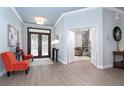 Bright entryway with double doors, light blue walls, and a glimpse into an adjacent living space at 5 Saint John Blvd, Englewood, FL 34223
