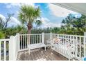 Charming white bench and table on a sunny patio with tropical foliage in the background at 7536 Palm Island S Dr # 1522, Placida, FL 33946