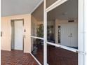 Inviting condo entrance featuring brick flooring, a secure door, and a convenient elevator at 11000 Placida Rd # 2702, Placida, FL 33946