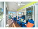 Screened porch featuring outdoor seating, ceiling fans, and views of palm trees and neighborhood at 130 Sand Dollar Ln, Englewood, FL 34223