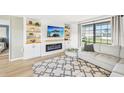Bright living room with a modern fireplace, stylish built-ins, and a large window at 1365 Sussex Rd, Venice, FL 34293