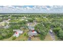 Scenic aerial view of a single-story house, neighborhood, and lush green landscape under a blue sky at 1386 Dewitt St, Port Charlotte, FL 33952