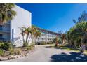 Stunning view of condominium building and lush landscaping with mature palm trees at 1401 S Mccall Rd # A 108, Englewood, FL 34223