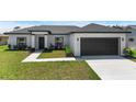 Well-maintained one story home with black and white accents and a manicured front lawn at 166 Bunker Rd, Rotonda West, FL 33947
