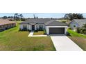 Well-maintained one story home with black and white accents and a manicured front lawn at 166 Bunker Rd, Rotonda West, FL 33947