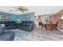 Inviting living room featuring comfortable leather seating, ceiling fan, and an adjacent dining area at 1670 Faust Dr, Englewood, FL 34224
