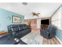 Cozy living room with a ceiling fan, comfortable seating, and a large television for entertainment at 1670 Faust Dr, Englewood, FL 34224